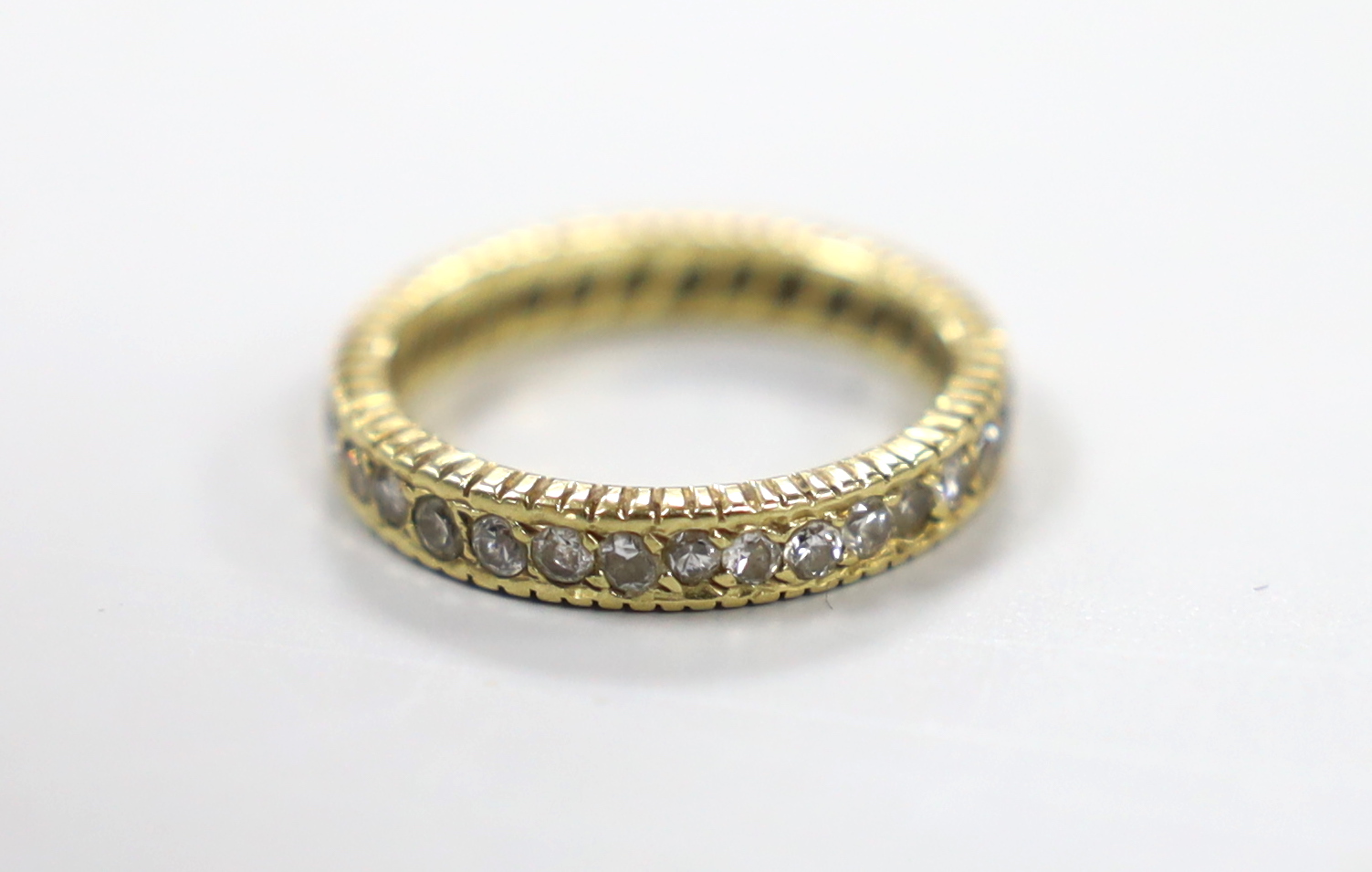 A yellow metal and diamond set full eternity ring, size L, gross weight 3.1 grams.